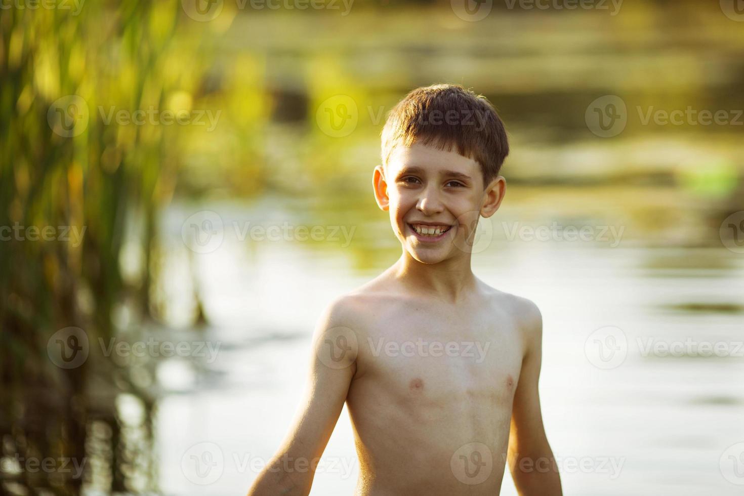 glücklicher kleiner Junge, der im Wasser steht foto