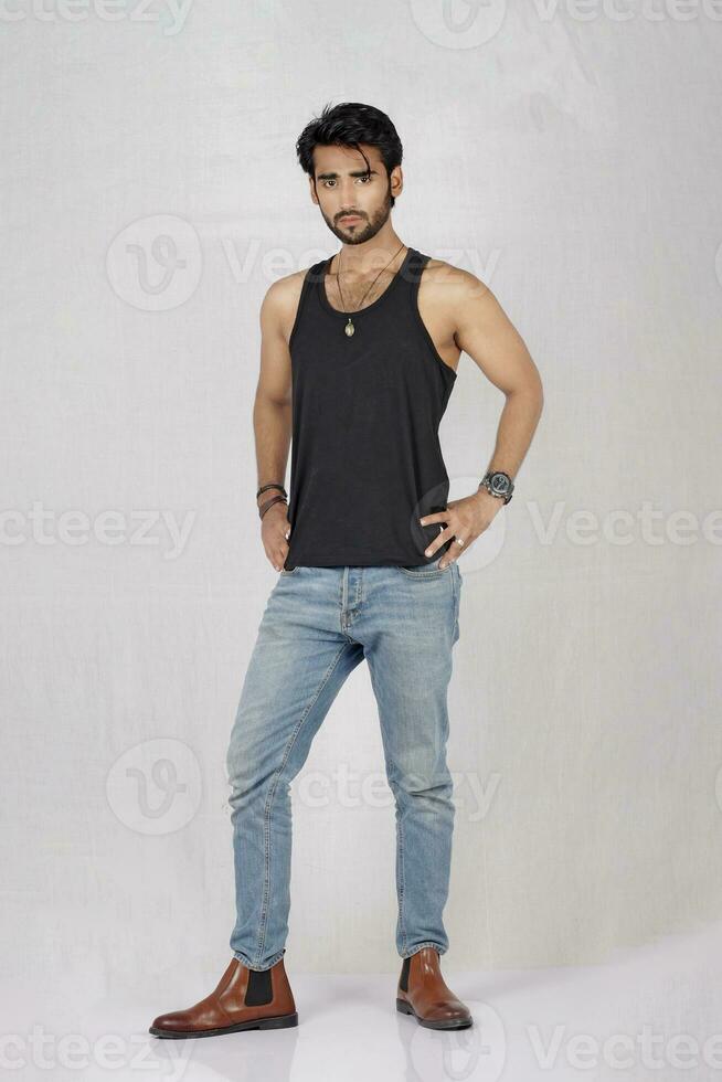 ein Mann im Jeans und ein schwarz Panzer oben foto