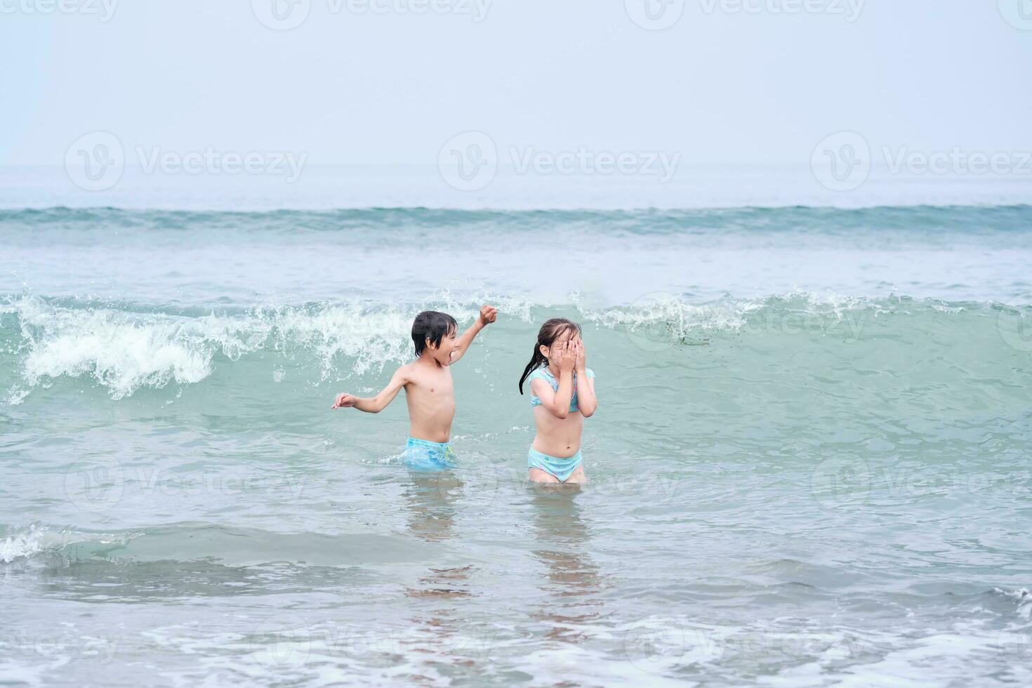 ein Junge und ein Mädchen sind haben Spaß spielen im das Meer. foto
