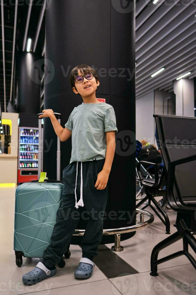 Junge mit ein Koffer beim das Flughafen. foto