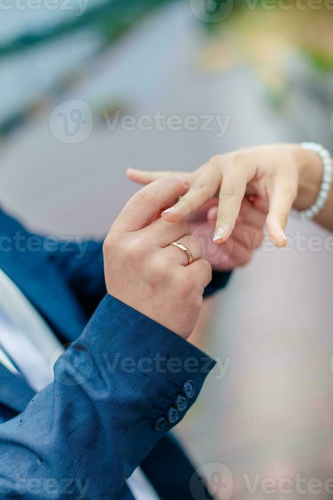 Bräutigam trägt Braut ein Hochzeit Ring auf seine Finger. ein Paar verloben foto