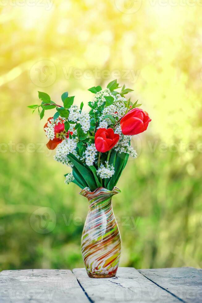 immer noch Leben von Vogel Kirsche und Tulpen. Strauß Blumen auf Hintergrund von Grün Gras. Hintergrund zum Gruß Karte mit Anfang von Frühling, März 8 oder Valentinstag Tag. foto