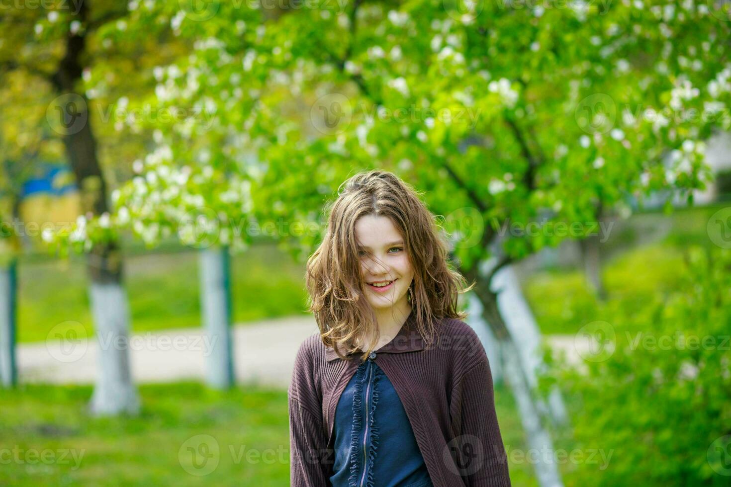 schön Mädchen unter Kirsche Blumen im Frühling. Porträt von ein Mädchen mit braun Haar und Grün Augen. foto