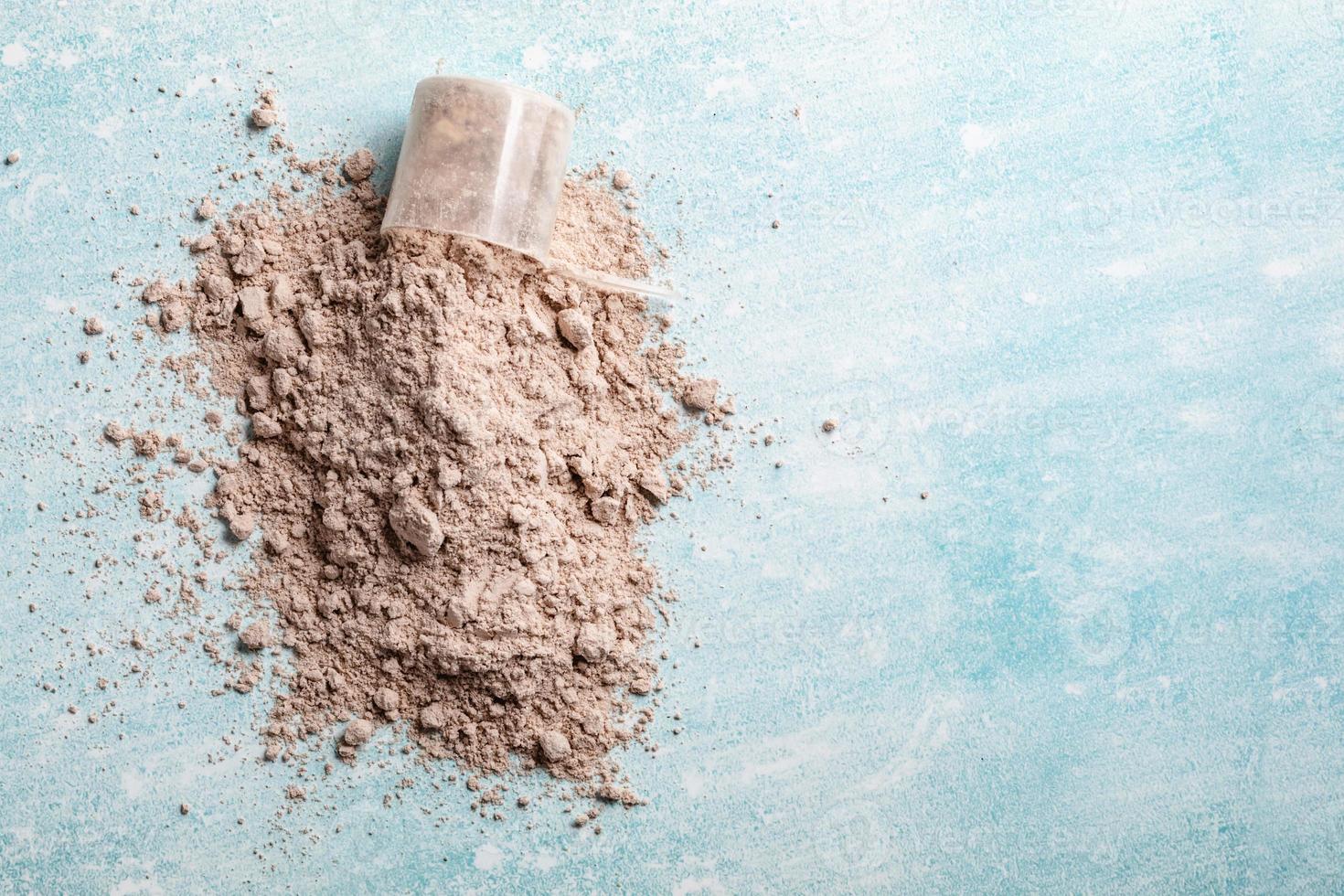 Draufsicht Whey Protein Schaufel auf blauem Hintergrund, Textfreiraum foto