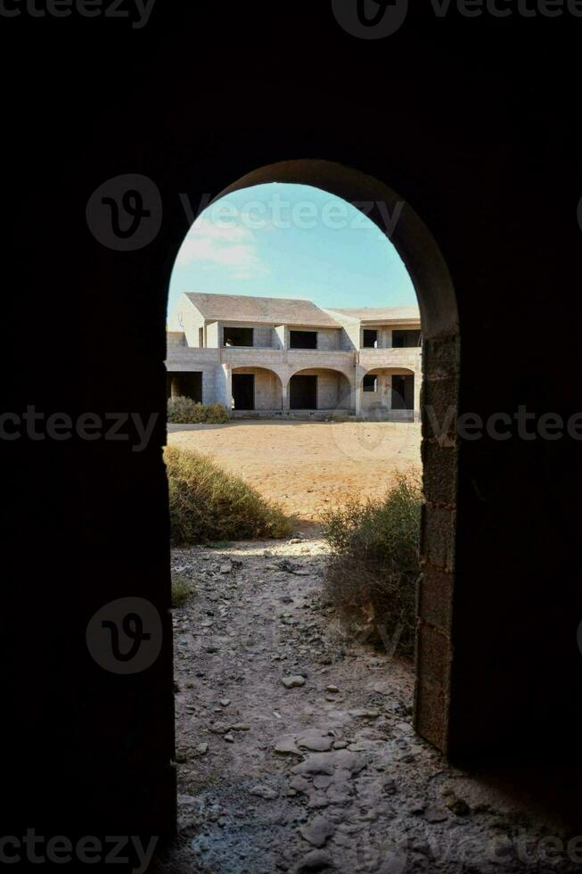 das Aussicht durch ein Torbogen zu ein alt Gebäude foto