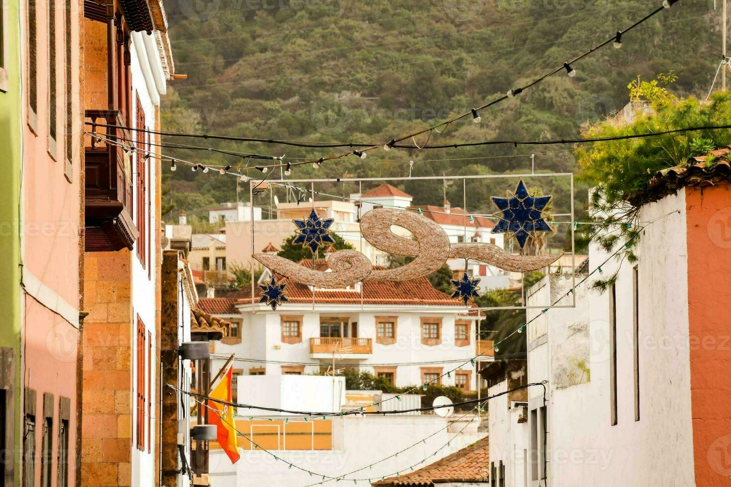 ein eng Straße mit ein wenige Gebäude und ein Berg im das Hintergrund foto