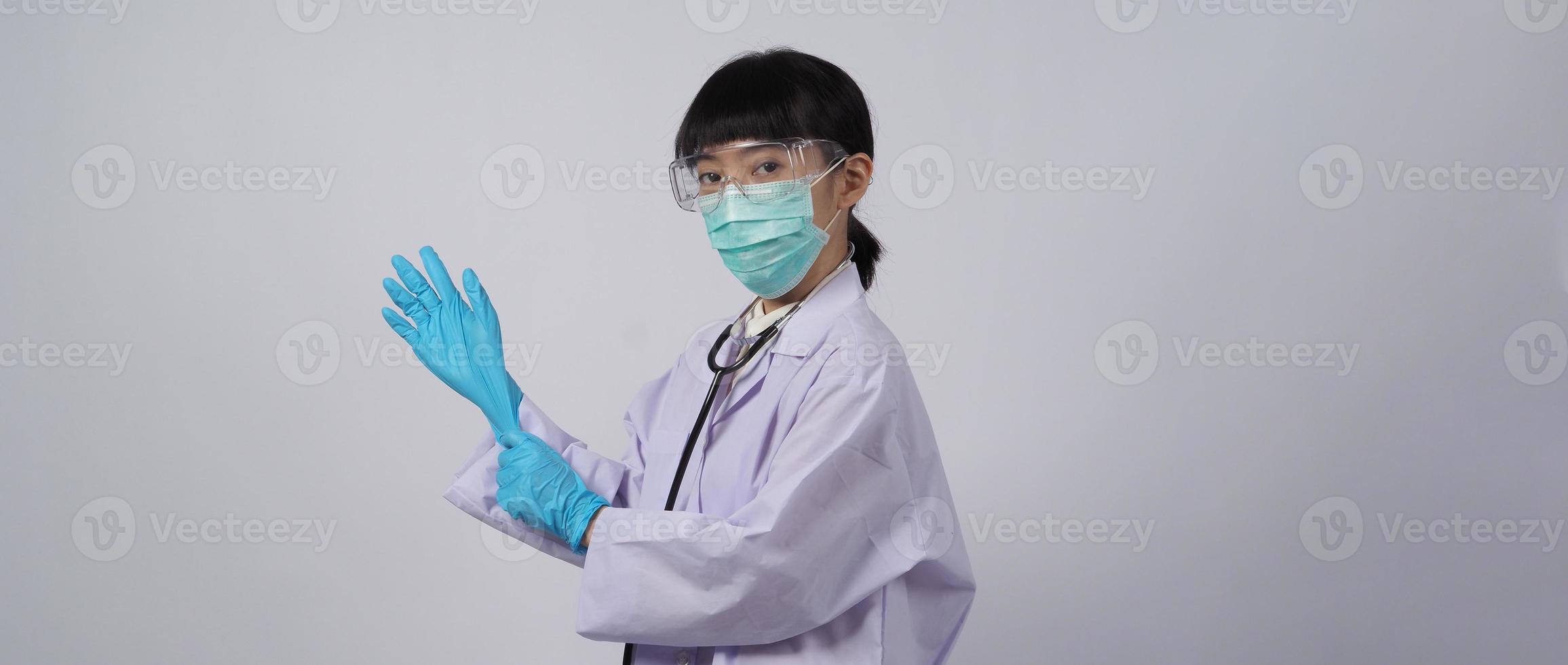 Handschuhe tragen. asiatischer Arzt trägt blauen Nitril-Gummihandschuh. foto