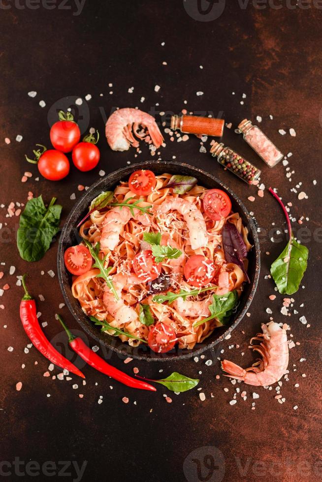 leckere Pasta mit Garnelen und Tomaten in einer Pfanne foto