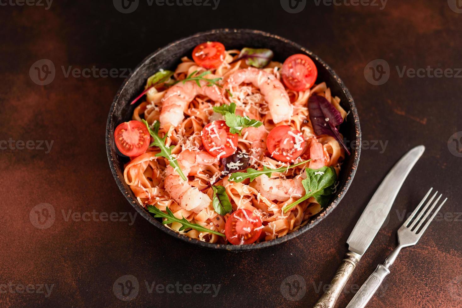 leckere Pasta mit Garnelen und Tomaten in einer Pfanne foto