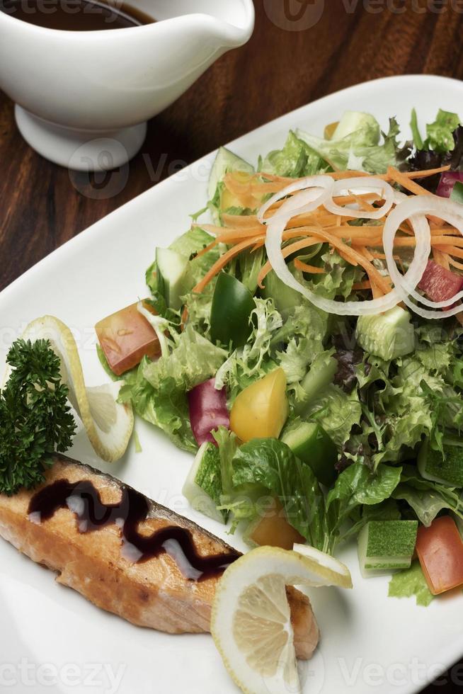 gemischter Bio-Gemüsesalat mit Lachsfilet und Balsamico-Vinaigrette foto