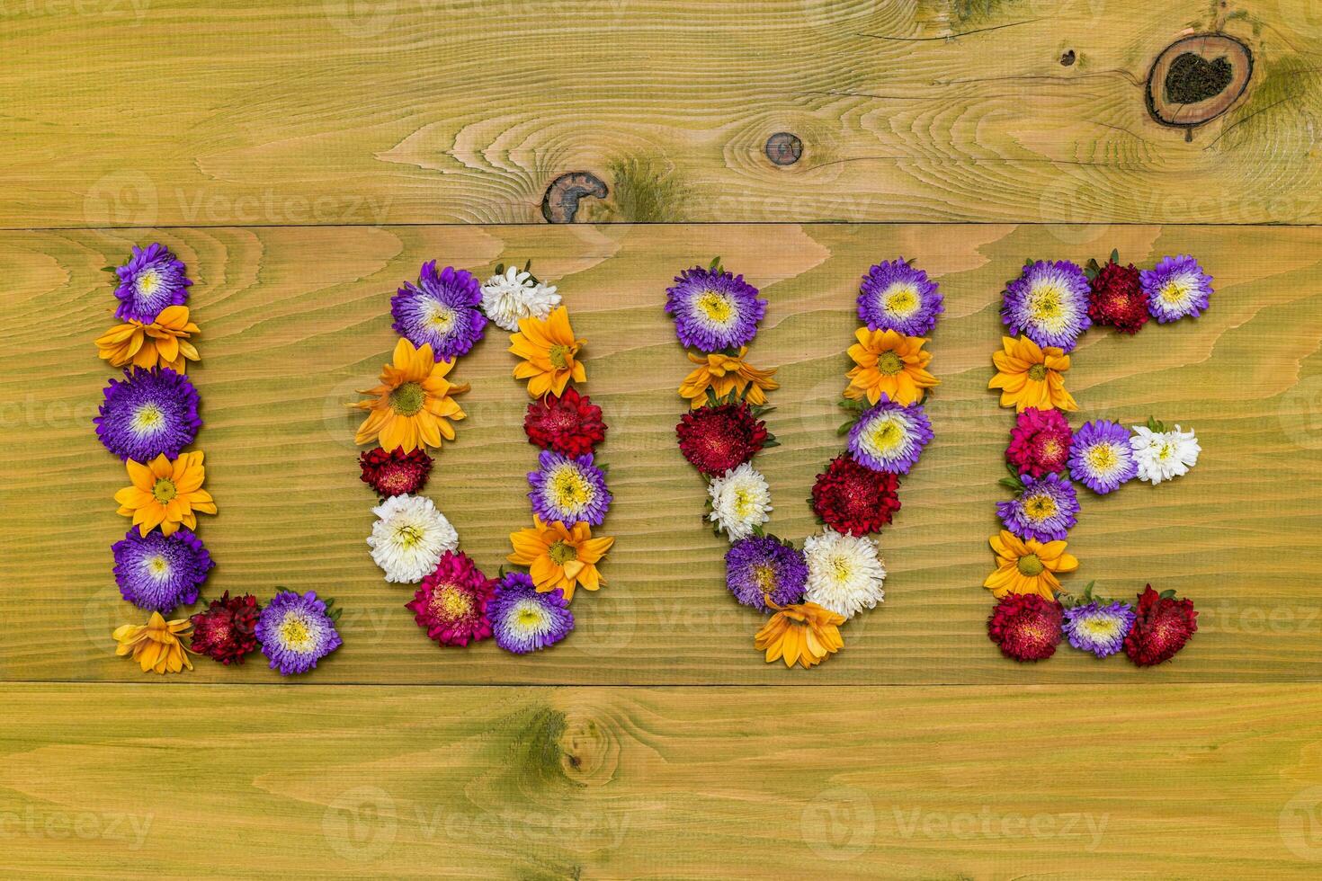 Bild von Wort Liebe gemacht von schön Blumen auf hölzern Hintergrund foto
