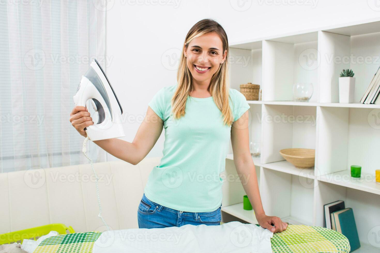 schön Frau Bügeln Kleider beim ihr Zuhause foto