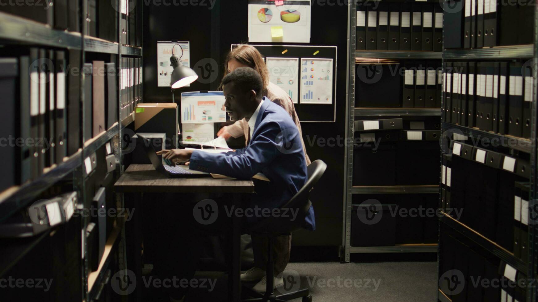 afrikanisch amerikanisch und kaukasisch Detektive zusammenarbeiten im Archiv Zimmer, Überprüfung Beweise und diskutieren führt. multiethnisch Gesetz Durchsetzung Agenten gewidmet zu lösen Verbrechen und Aufrechterhaltung Gerechtigkeit. foto