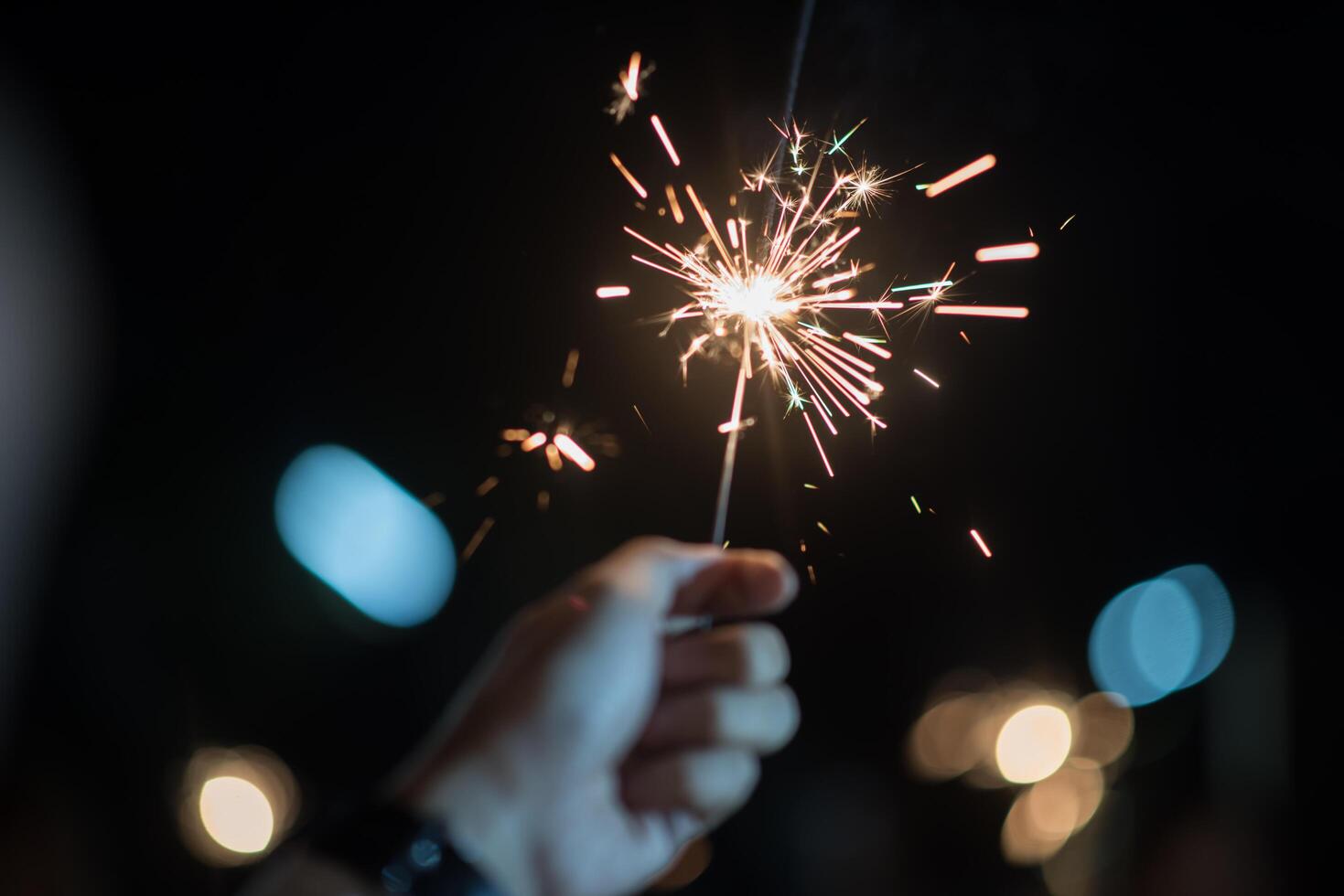 Hand hält eine brennende Wunderkerze foto