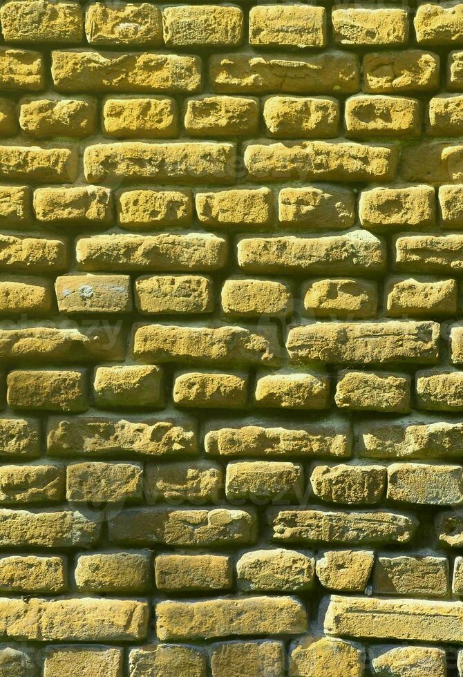 Vertikale Wandstruktur aus mehreren Reihen sehr alter Mauerwerke aus rotem Backstein. zerbrochene und beschädigte Ziegelwand mit eingeklemmten Ecken foto