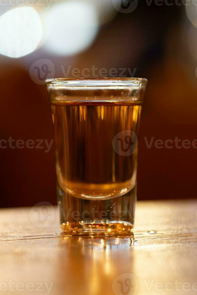 schließen oben von Schuss Glas auf Holz Tabelle mit verwischen Restaurant Hintergrund foto