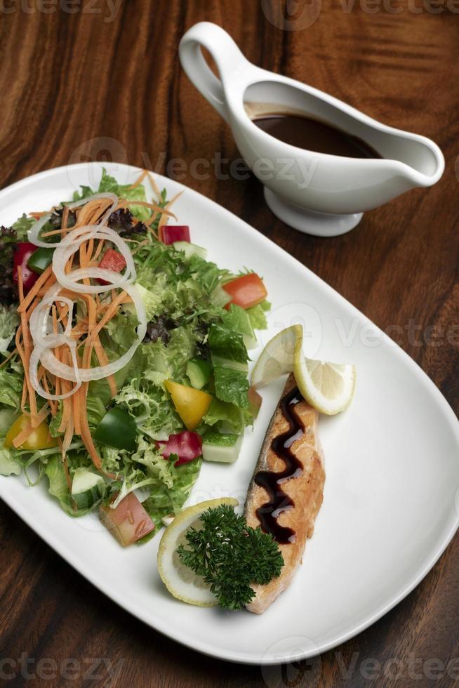 gemischter Bio-Gemüsesalat mit Lachsfilet und Balsamico-Vinaigrette foto