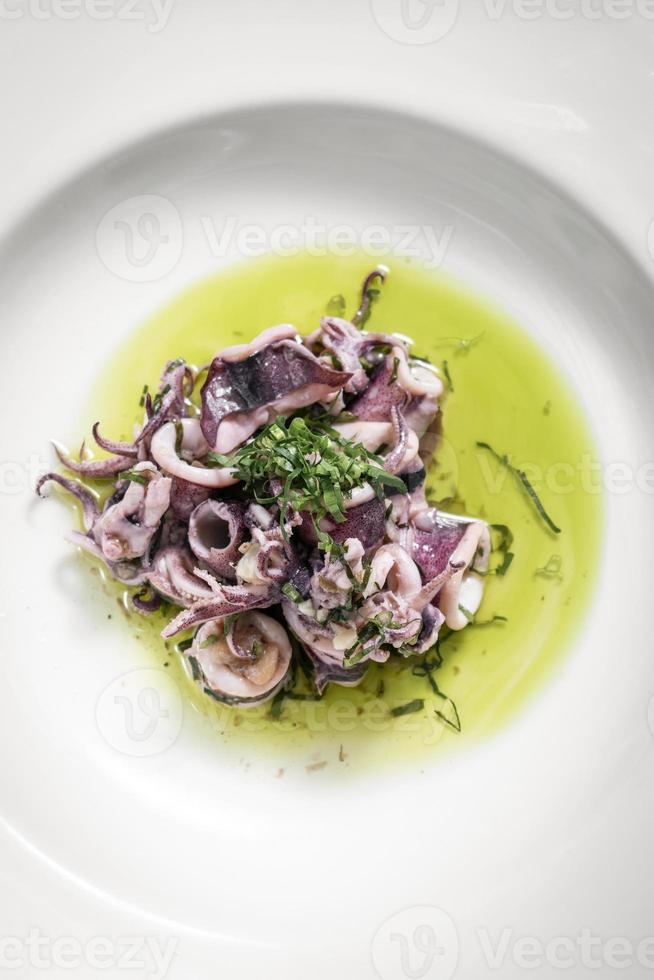 portugiesischer traditioneller marinierter Tintenfischsalat mit frischen Meeresfrüchten in Korianderöl foto