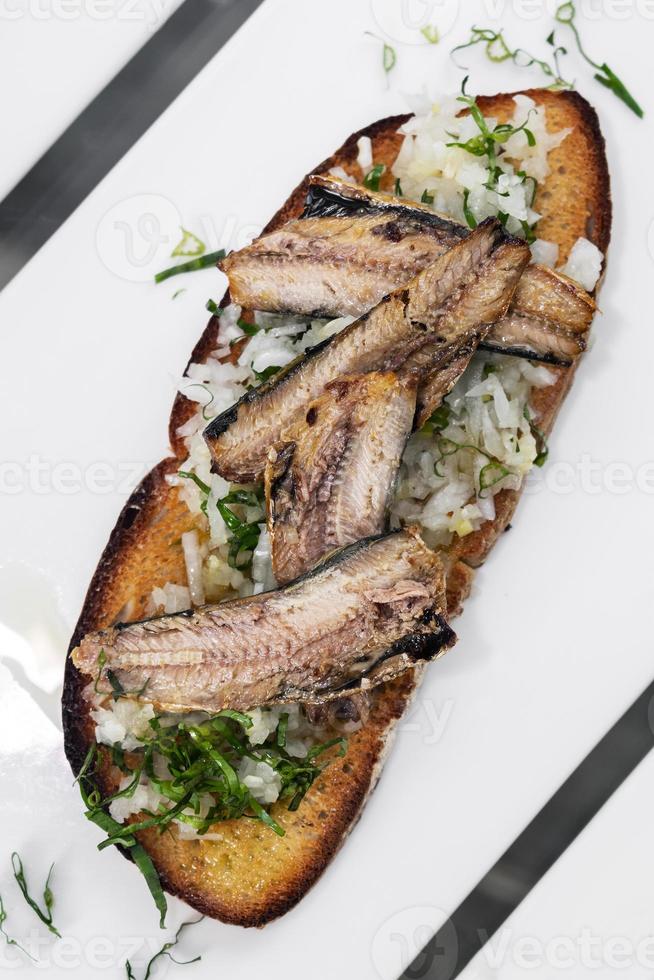 portugiesische Tiborna Open Toast Sandwich-Tapas mit Sardinen und Zwiebel-Knoblauch foto