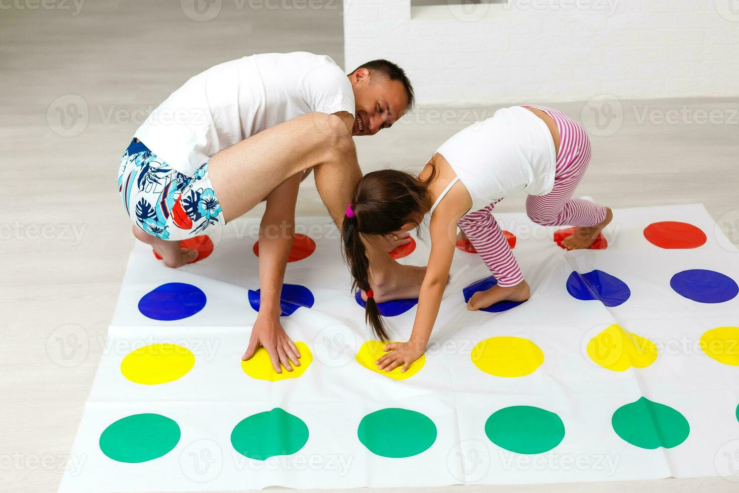 Tochter und Vater abspielen Twister beim Zuhause foto