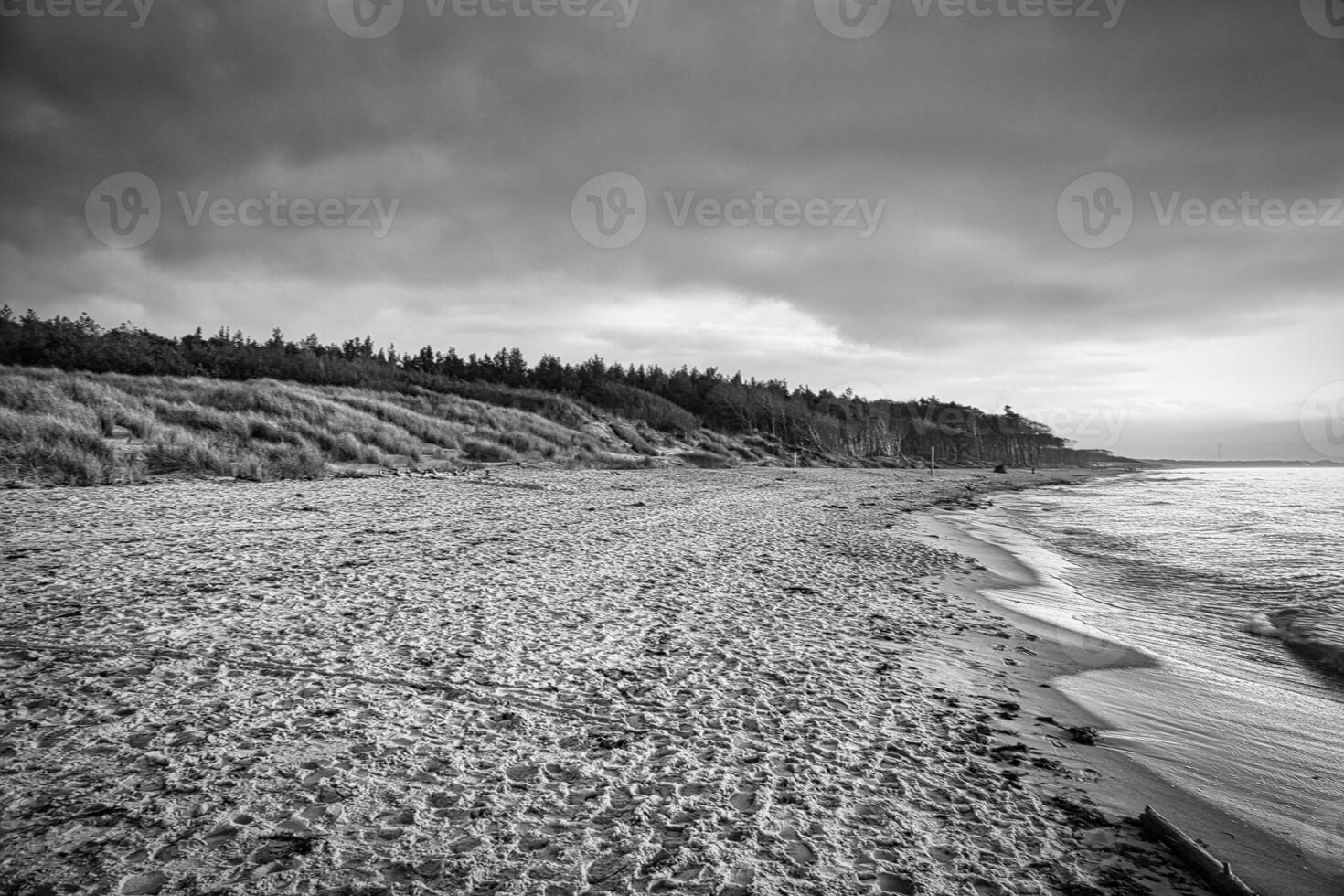 Sonnenuntergang auf das Westen Strand auf das baltisch Meer im schwarz und Weiß. Wellen, Strand, Himmel foto