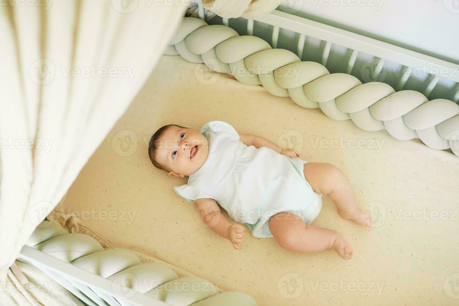 bezaubernd glücklich Baby Lügen im Krippe oben Aussicht foto
