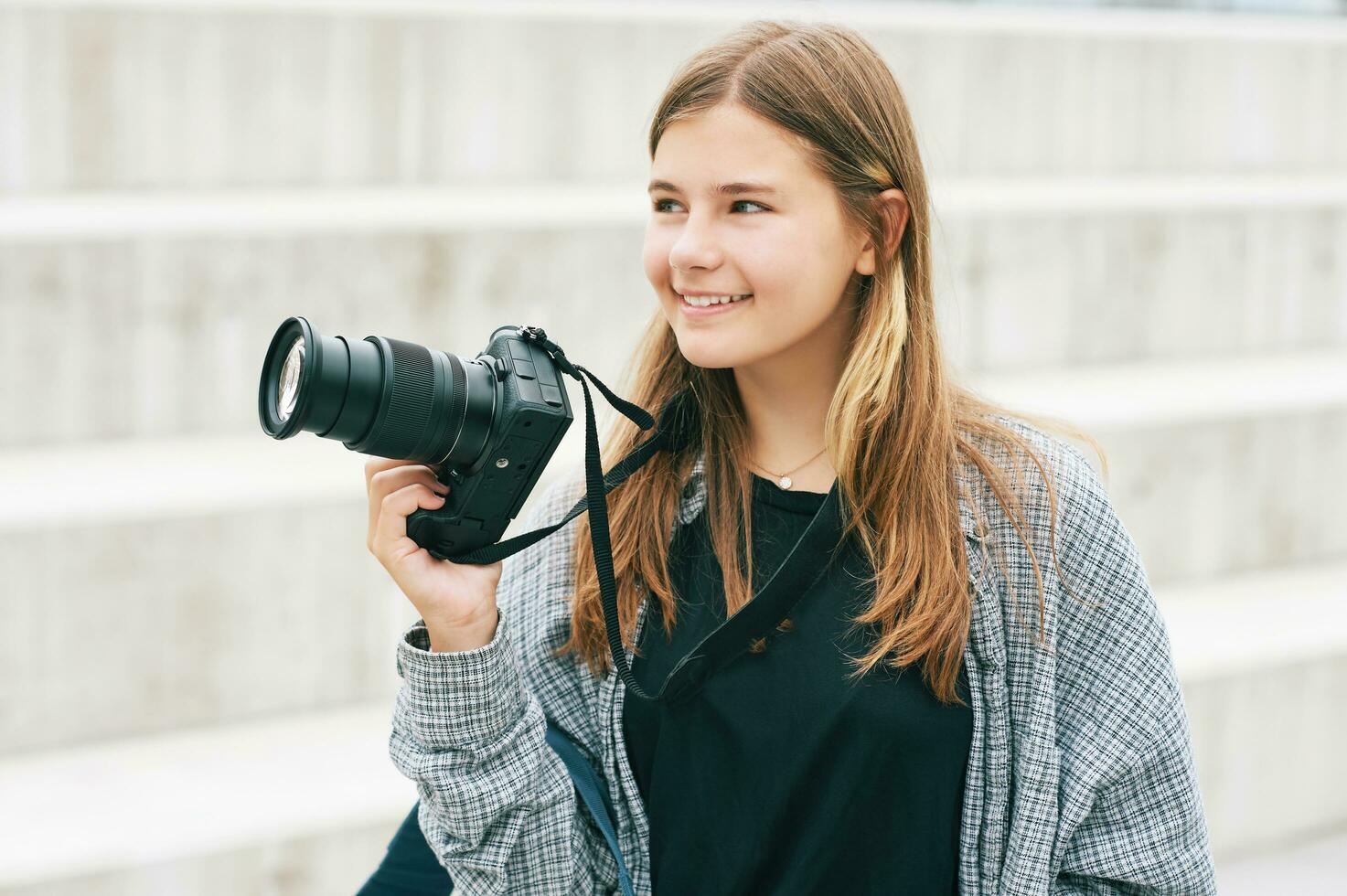 draussen Porträt von jung glücklich Teenager Mädchen halten spiegellos Kamera foto