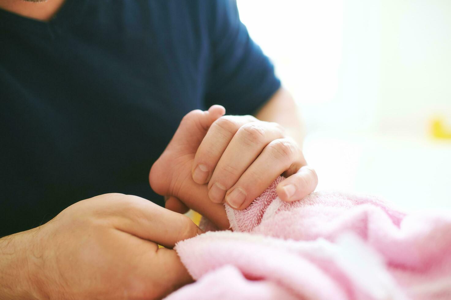 Vater nehmen Pflege von Neugeborene Baby, Trocknen Kind mit Handtuch nach Badezeit foto