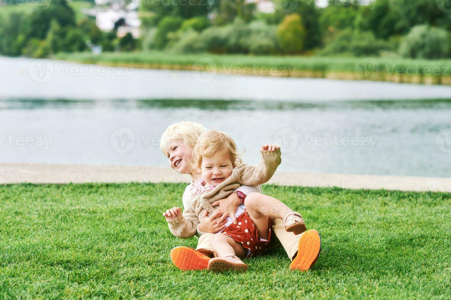 draussen Porträt von bezaubernd glücklich Kinder spielen zusammen Nächster zu See oder Fluss, Geschwister Liebe foto