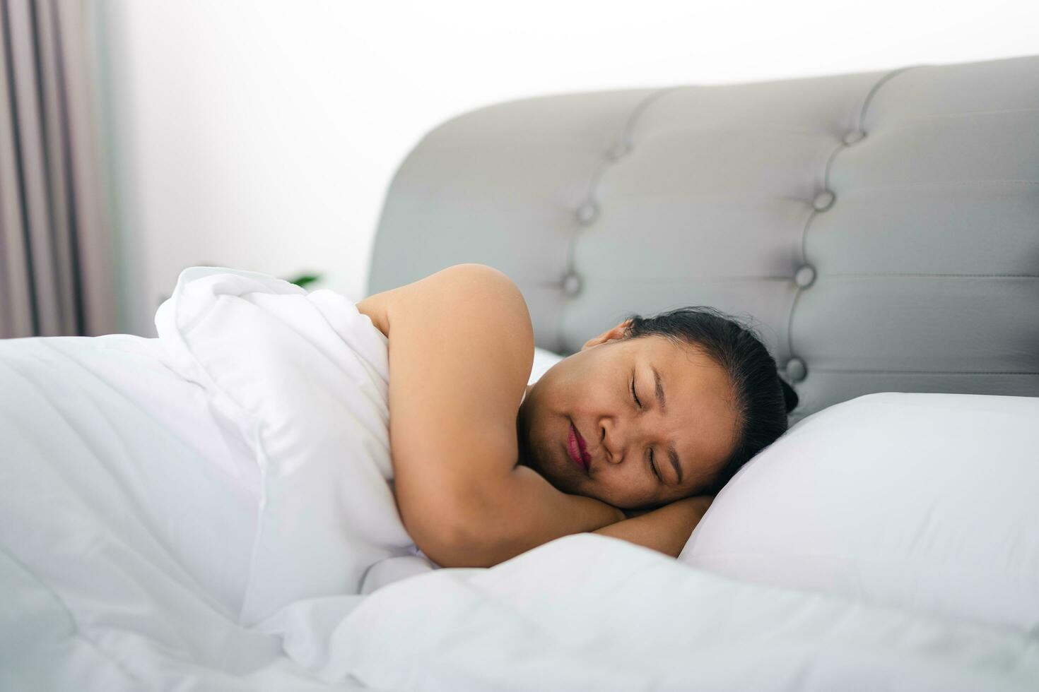 reifen Frau Schlafen auf das Weiß Bett beim heim. foto