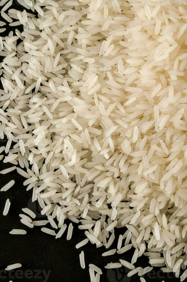 ein Stapel von Weiß Reis auf ein schwarz Oberfläche foto