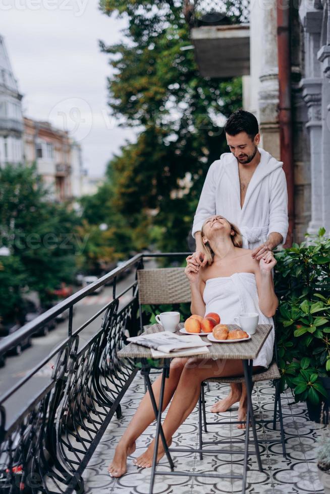 Schwangere Frau mit Mann auf dem Balkon treffen sich morgens foto