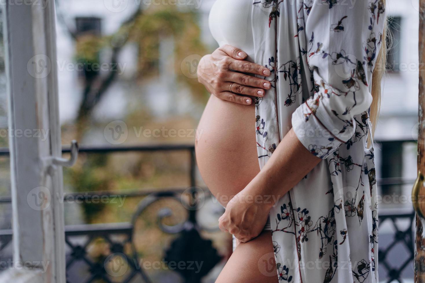Mittelteil der schwangeren Frau Nahaufnahme Profil auf dem Balkon foto