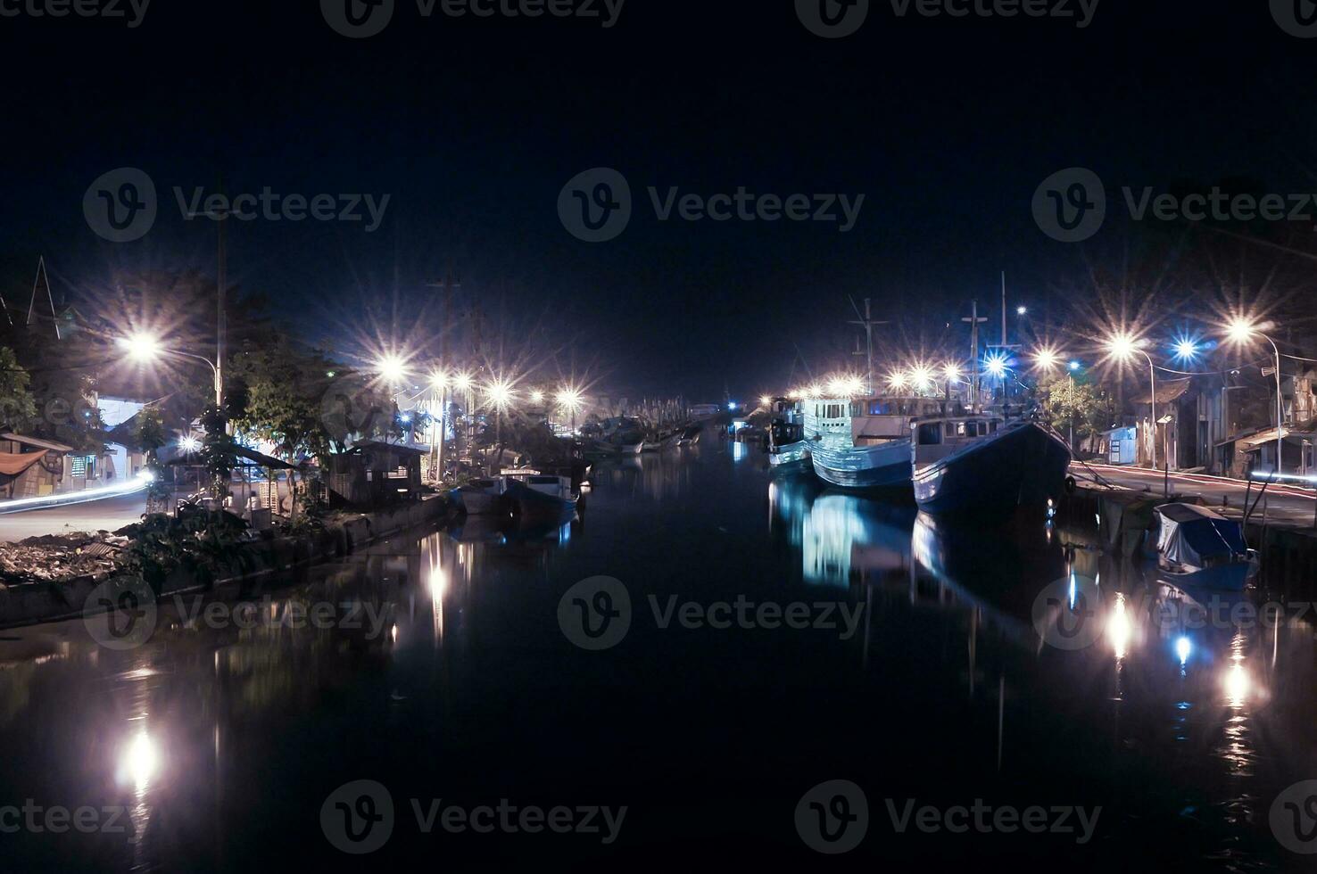 stromaufwärts von das Fluss beim pasuruisch Hafen im Indonesien, viele Angeln Boote Dock beim Nacht foto