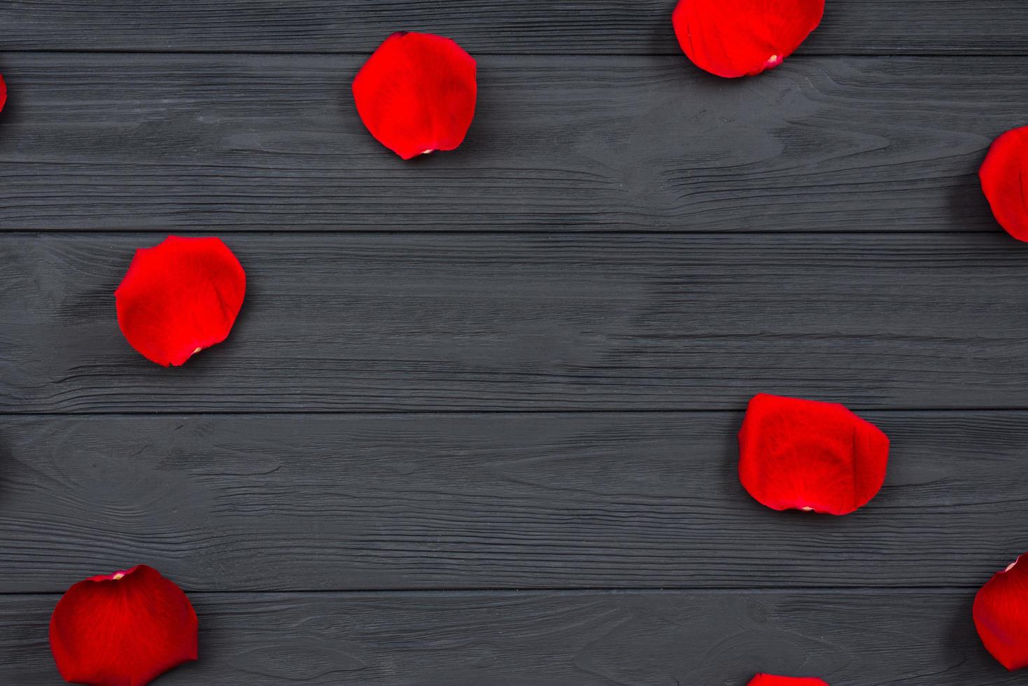 rote Rosenblätter auf Holzuntergrund. foto