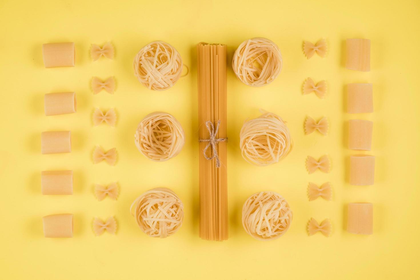 verschiedene Arten von Nudeln auf gelbem Hintergrund. verschiedene Pasta-Formen. foto