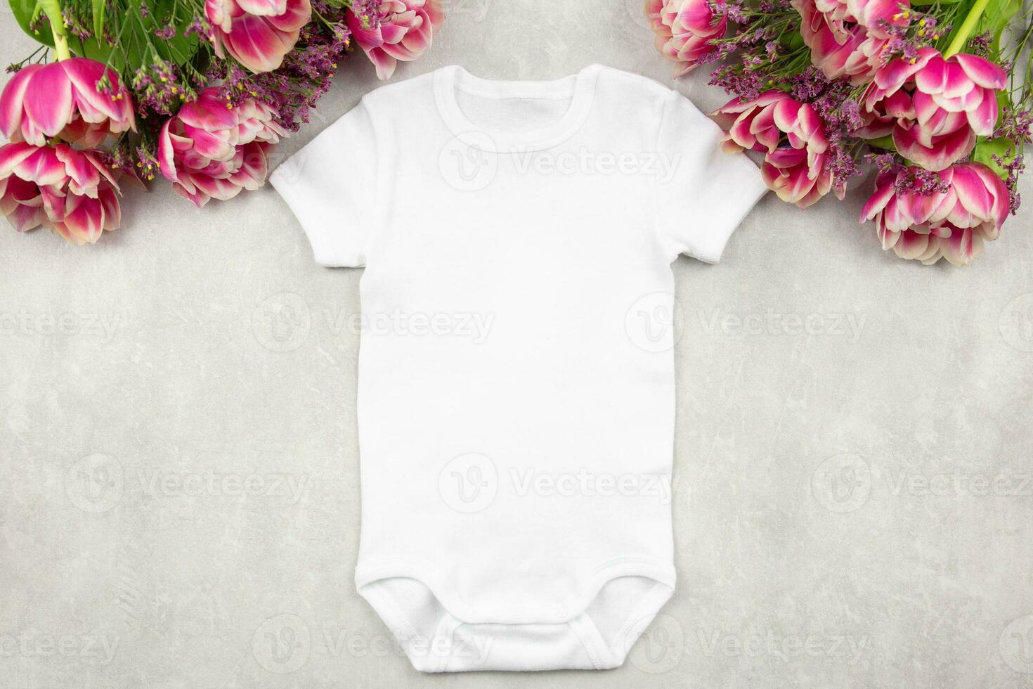 Weiß Baby Mädchen oder Junge Bodysuit Attrappe, Lehrmodell, Simulation eben legen mit Tulpe Blumen auf grau Beton Hintergrund. Design Strampler Vorlage, drucken Präsentation spotten hoch. oben Sicht. foto