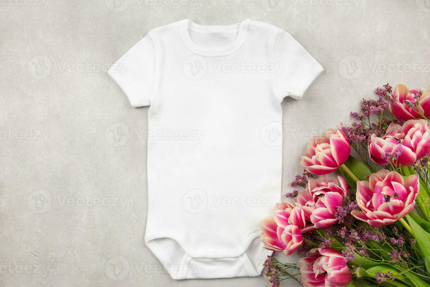 Weiß Baby Mädchen oder Junge Bodysuit Attrappe, Lehrmodell, Simulation eben legen mit Tulpe Blumen auf grau Beton Hintergrund. Design Strampler Vorlage, drucken Präsentation spotten hoch. oben Sicht. foto