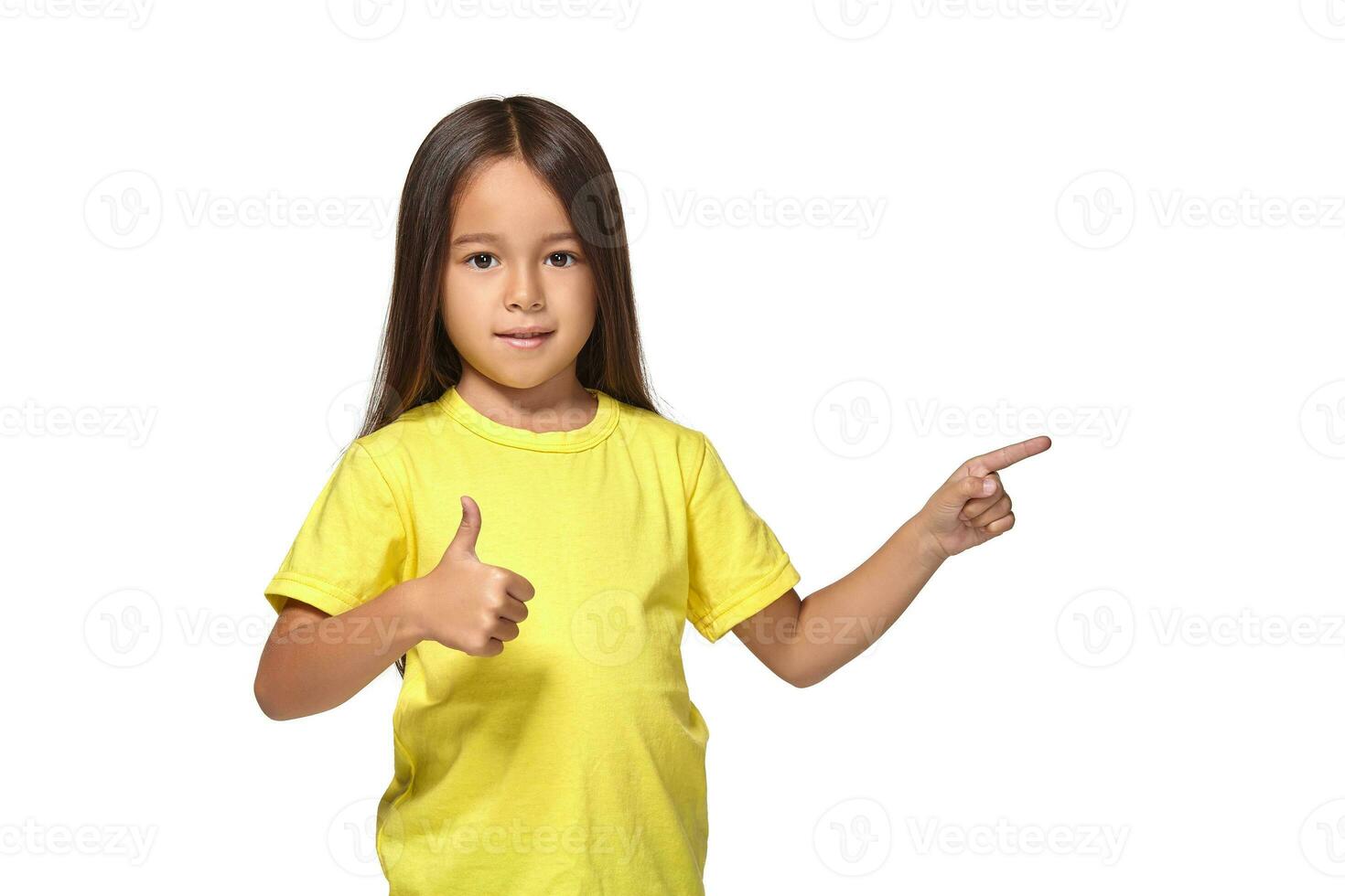 Mädchen im Gelb T-Shirt zeigt an ihr Hände mit Daumen foto