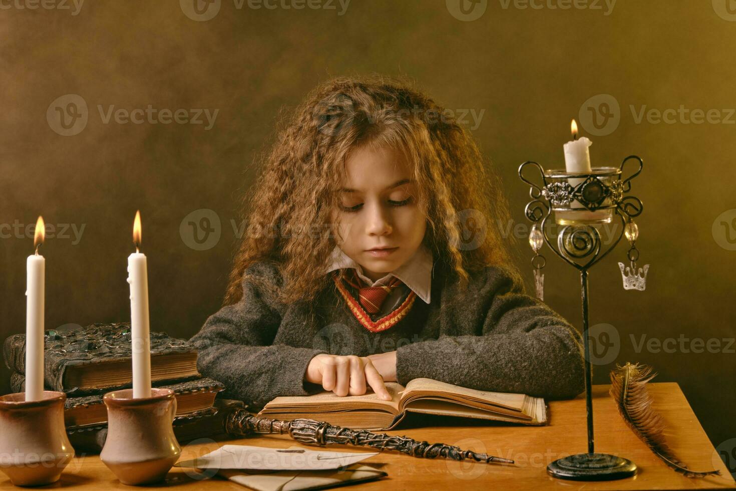 wenig Hexe gekleidet im dunkel Kleider Sitzung beim das Tabelle gegen schwarz rauchig Hintergrund und lesen ein Buch. Nahansicht Porträt. foto