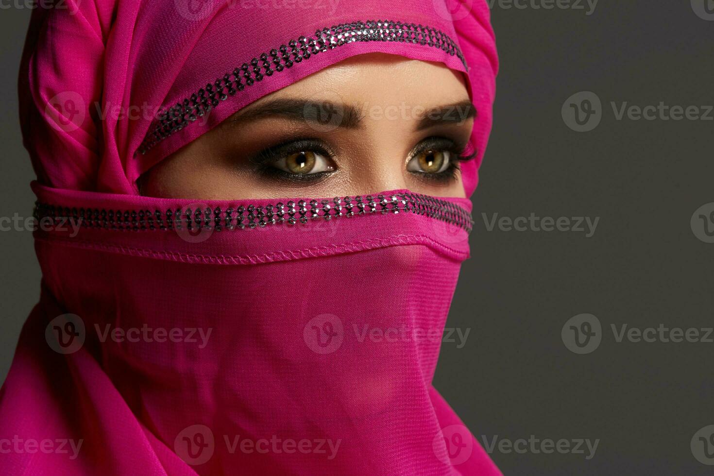 Nahansicht Schuss von ein jung charmant Frau tragen das Rosa Hijab dekoriert mit Pailletten. Arabisch Stil. foto