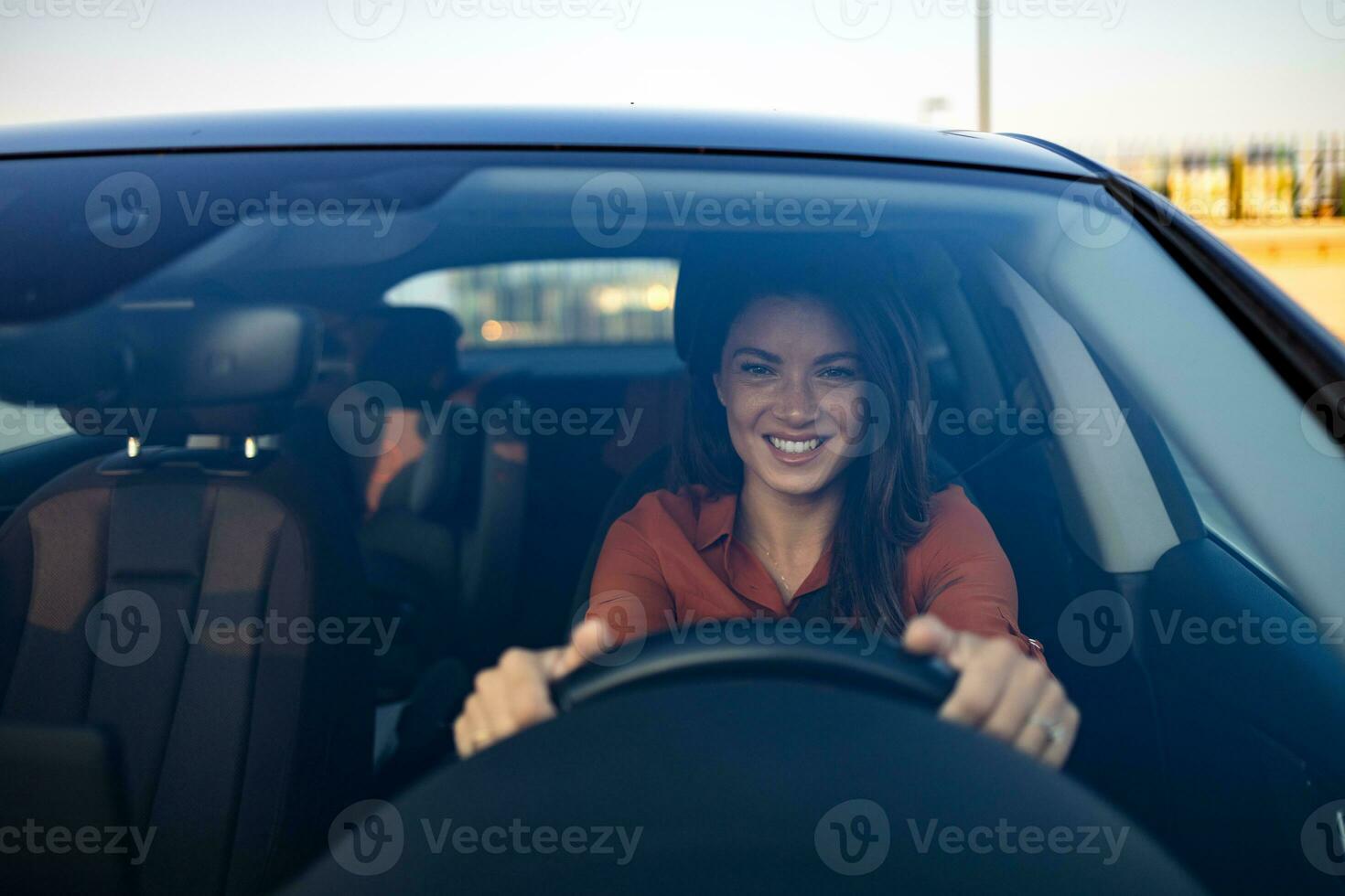 glücklich Frau Fahren ein Auto und lächelnd. süß jung Erfolg glücklich Brünette Frau ist Fahren ein Wagen. Porträt von glücklich weiblich Treiber Lenkung Auto mit Sicherheit Gürtel foto