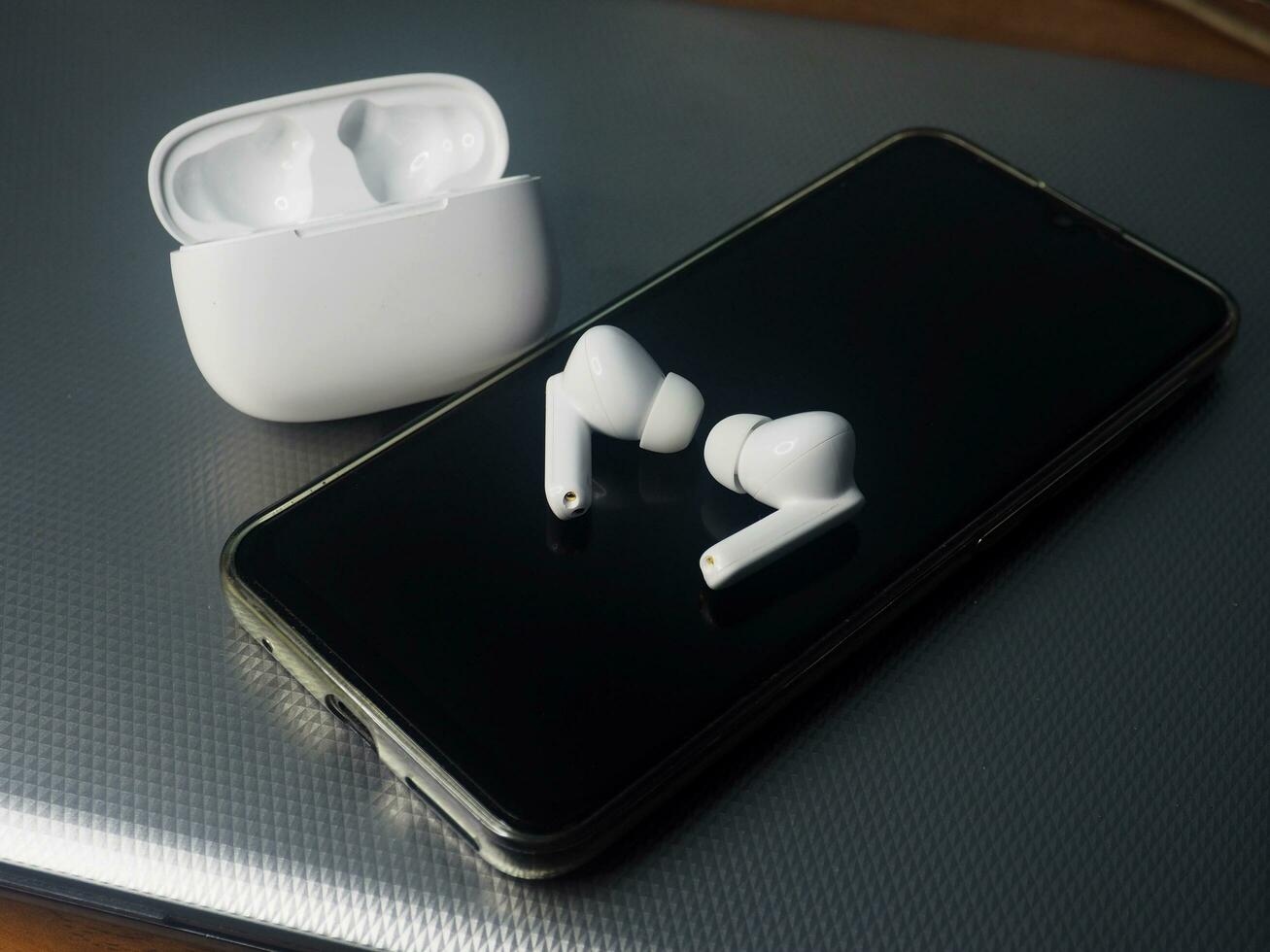 Weiß Ohrhörer und Clever Telefon verbinden zusammen foto