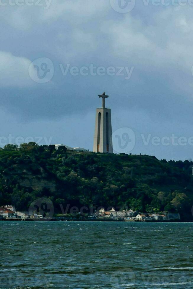 ein groß Statue auf oben von ein Hügel mit Blick auf das Ozean foto