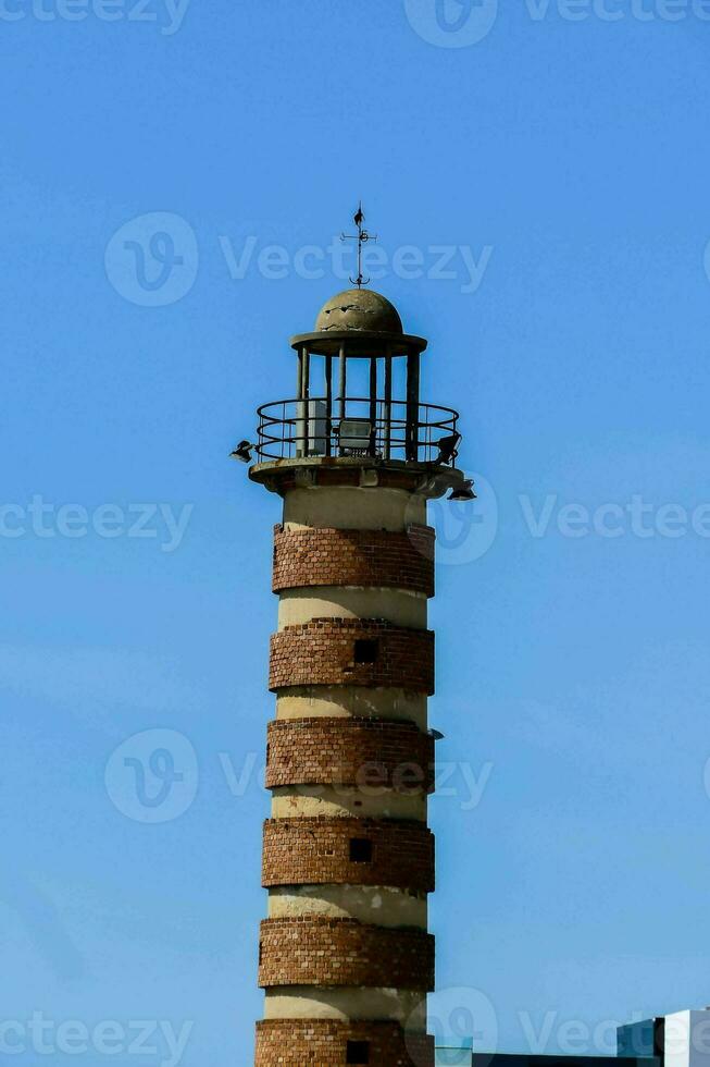 ein Leuchtturm Turm mit ein Vogel auf oben foto