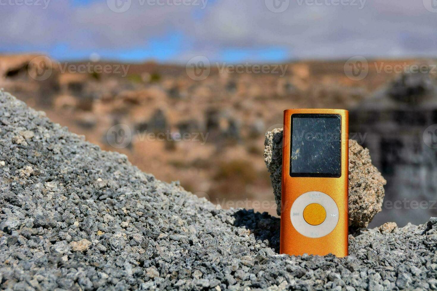 ein Orange ipod Sitzung auf oben von ein Stapel von Felsen foto