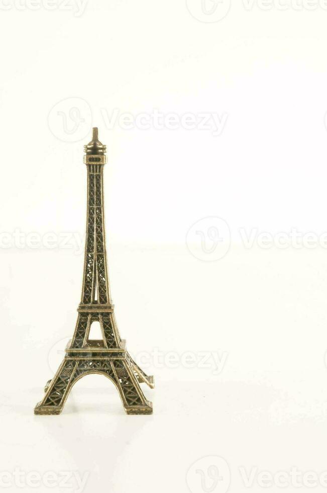 ein klein Metall Eiffel Turm auf ein Weiß Hintergrund foto