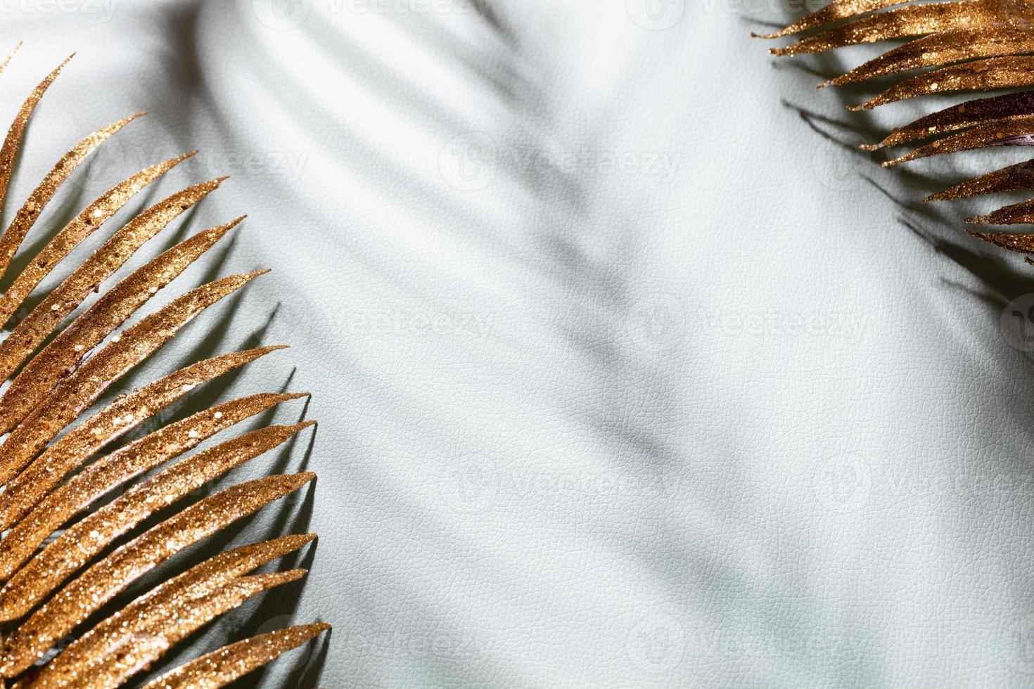 goldene Palmblätter und Schatten auf blauem Wandhintergrund. foto