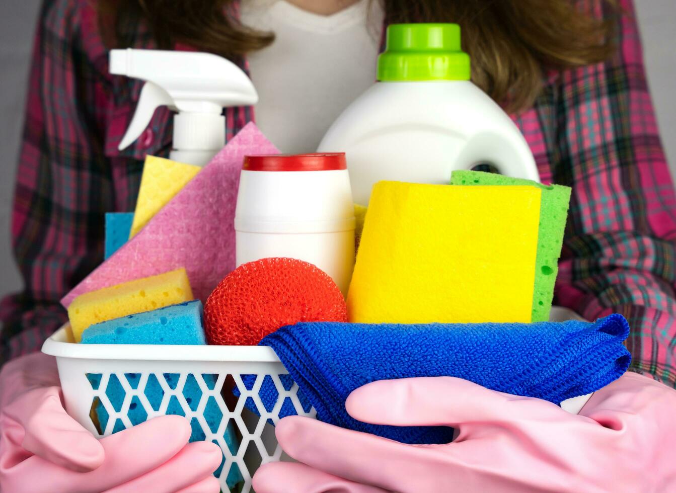 ein Frau im Gummi Handschuhe hält Waschmittel und Reiniger zum Reinigung das Haus. Nahansicht. selektiv Fokus. foto