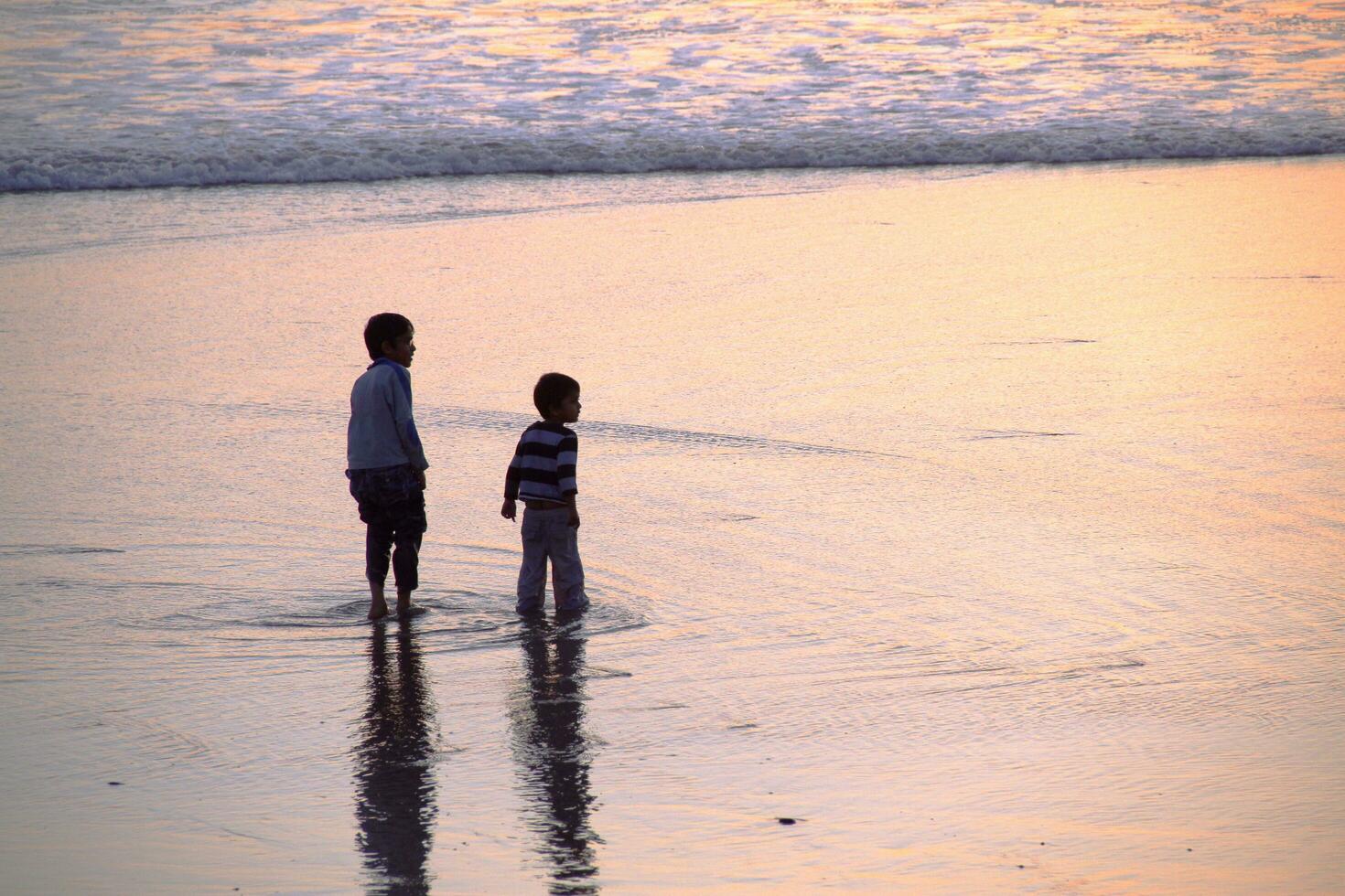 Jungs abspielen im Wellen beim Santa Monica Strand foto